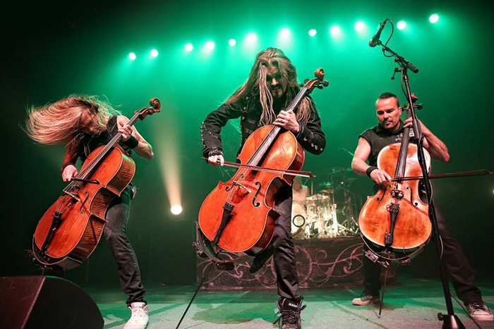 Apocalyptica backlit by green stage lights.