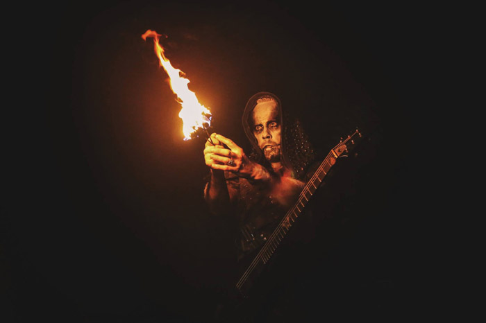 The front-man for Behemoth holding fire performance equipment.