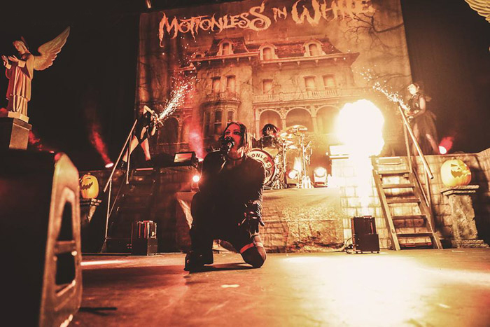 The lead singer for Motionless in White, with pyrotechnics disrupting the lighting.