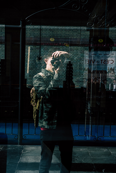 Photography of a person taking a photograph reflected in a shop window. Self portrait photography tips.