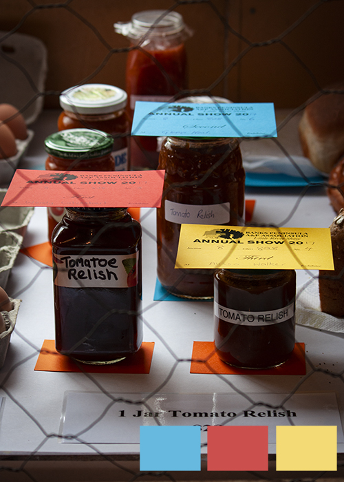 Jars of jam and relish with red, yellow and blue cards on the lids and squares of triadic color in photography examples in the lower right corner