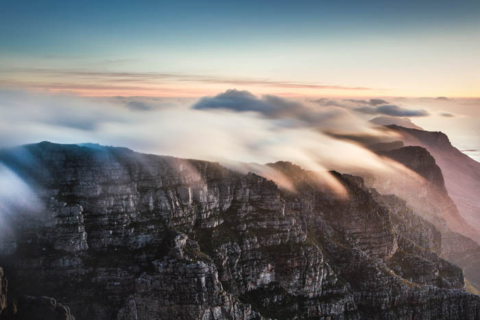 Atmospheric landscape shot of rocky cliff stops covered in mist and fog, cloudy day photography