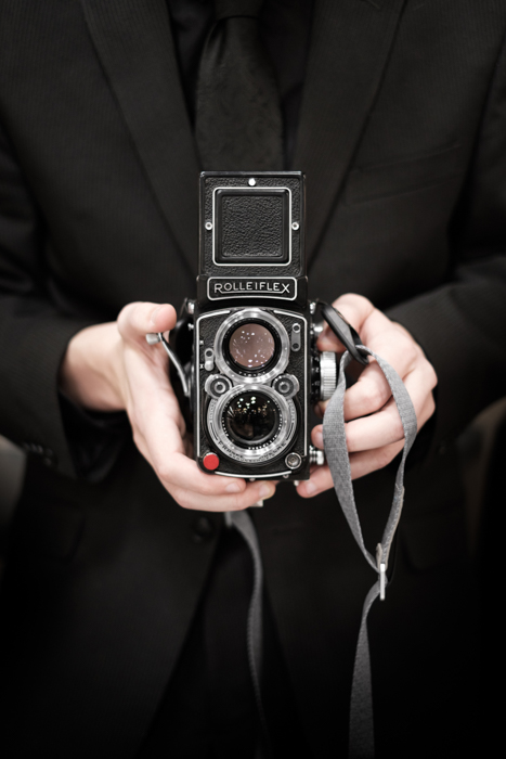 A person holding a Rolleiflex film camera - viewfinder info