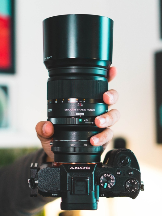 a photographer holding a Sony DSLR with a constant aperture lens