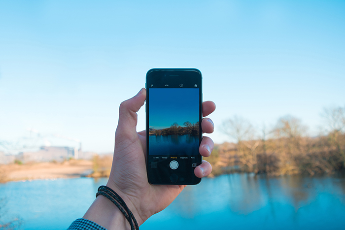 a person taking a landscape photo with a smartphone 