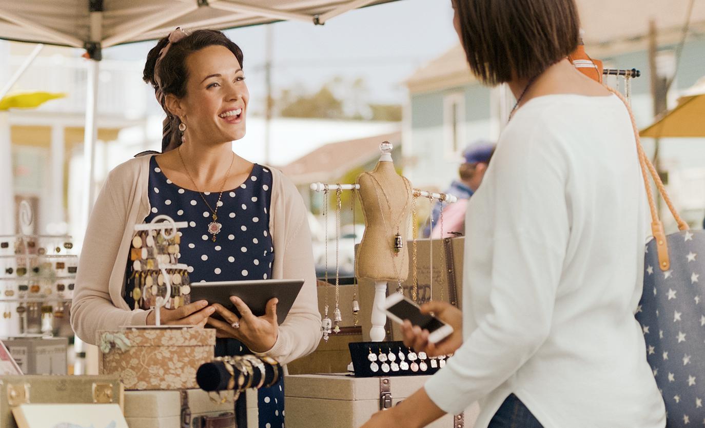 A woman customer talking to a vendor at an outdoor market